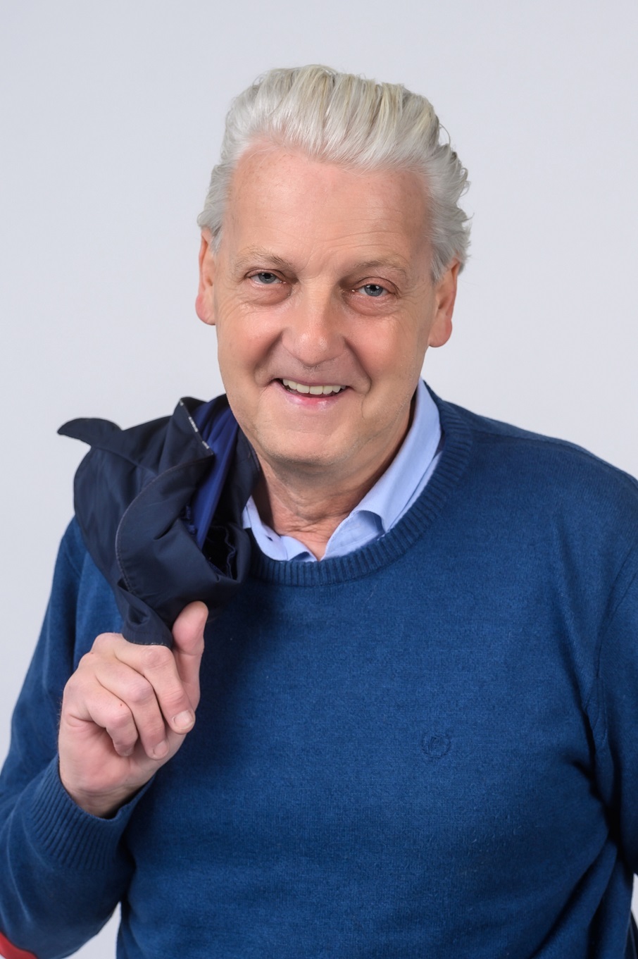 Hollabrunner Bürgermeister Babinsky, Foto Gesicht und Oberkörper, bekleidet mit blauem Pullover und Jacke die lässig über die rechte Schulter nach hinten liegt.